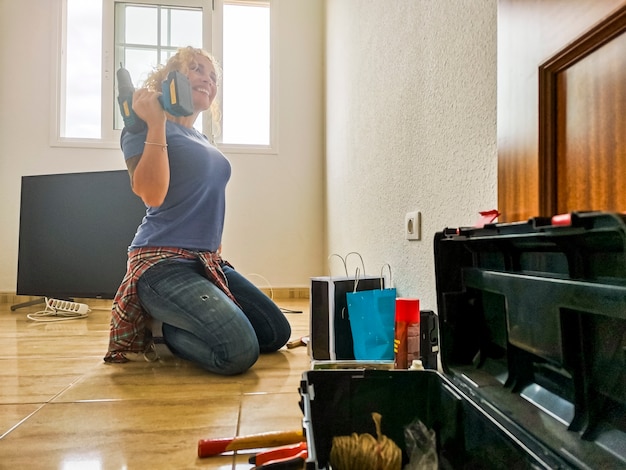 Фото Счастливая и усталая женщина отдыхает на полу после домашних работ во время ипотеки