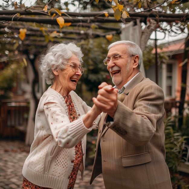 写真 幸せで若い年配の活躍する夫婦は一緒に踊り野外のレクリエーション活動で楽しんでいます 年配の年配の男性と女性が外で踊り愛で笑っています