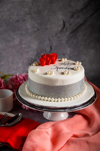 Happy anniversary White Pearl Cake or women day and valentine celebration with flowers spoon and fork served on board isolated on napkin side view of cafe bake food