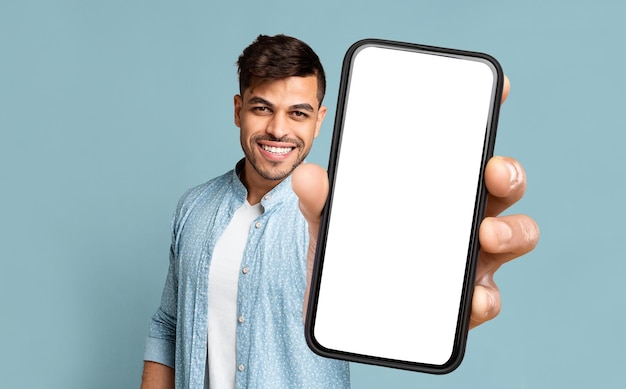 Happy Arab Man Showing Smartphone With Empty Screen