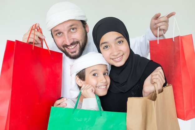 Happy Arabic family having fun time with shopping bags