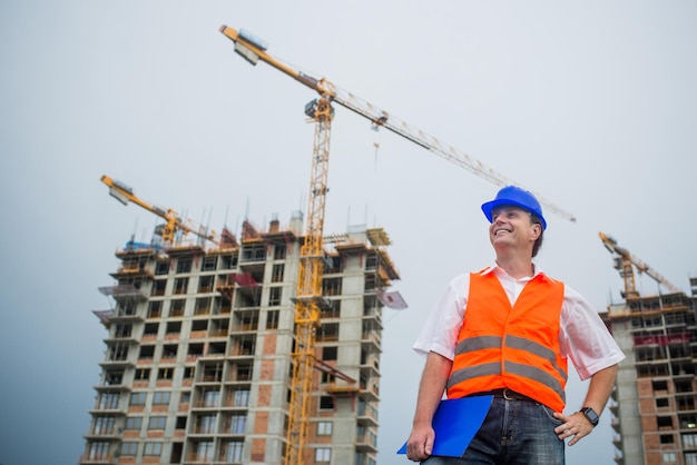 Happy architect on a construction site during a housing project