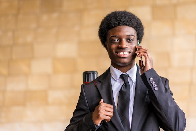 Photo happy architect with afro hairstyle and suit talking by phone