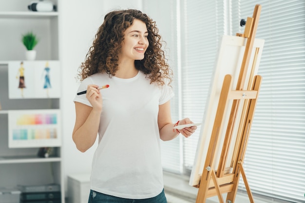 The happy artist painting a picture on the easel