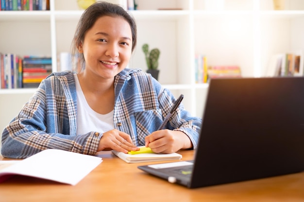 Happy asain girl use laptop study at homeLibrary room