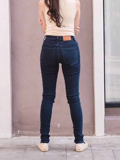 Happy Asia woman in denim skinny jeans, midnight blue jeans, back view