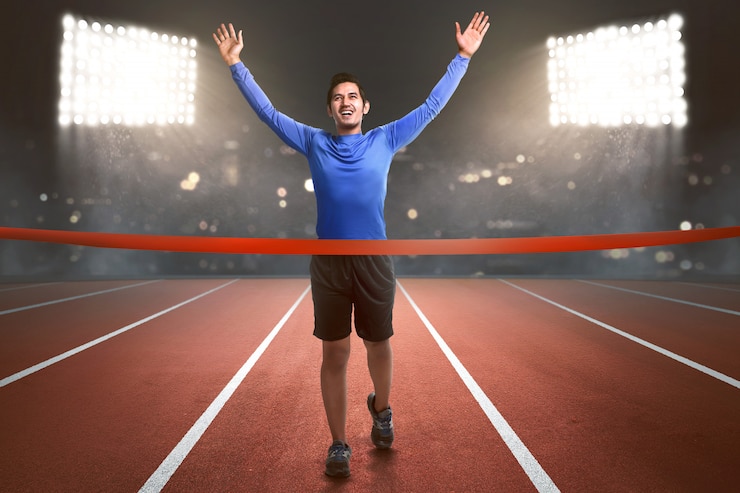 Photo happy asian athlete man running to finish line