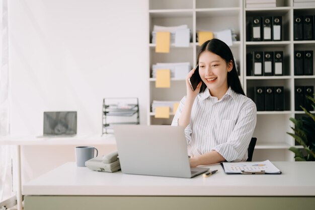 Photo happy asian business woman have the joy of talking on the smartphone tablet and laptopon the office xa