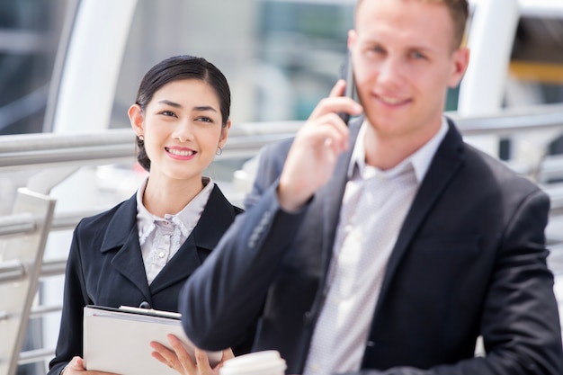 Happy Asian Businesswoman interesting to Assist Project with Businessman.