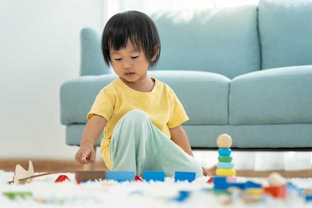 Photo happy asian child playing and learning toy blocks children are very happy and excited at home child have a great time playing activities development attention deficit hyperactivity disorder