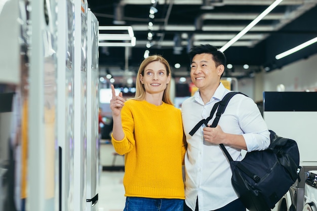 Happy asian couple family man and woman make a choice choose of new household home appliances in