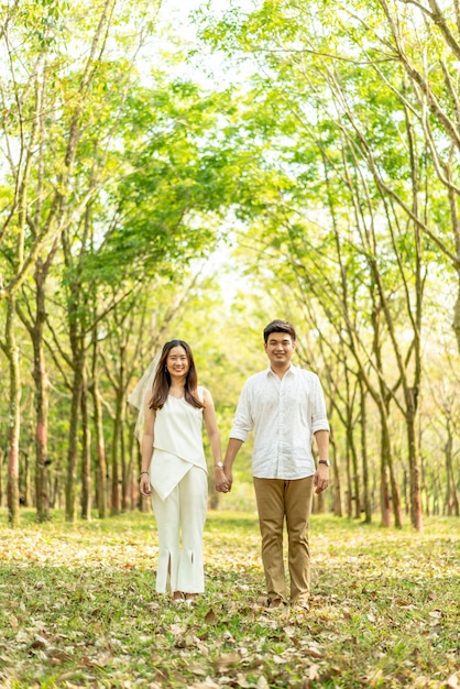 Coppie asiatiche felici nell'amore con l'arco dell'albero