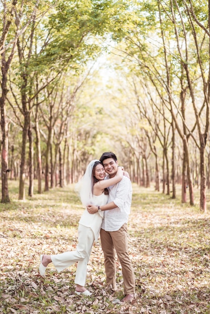 Happy asian couple in love with tree arch