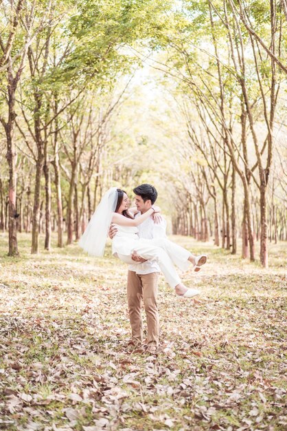 Coppie asiatiche felici nell'amore con l'arco dell'albero