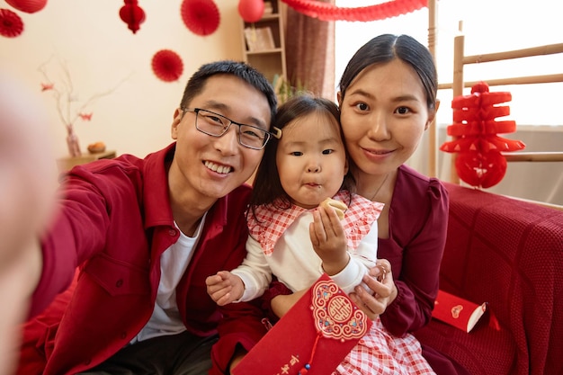 Happy asian family on chinese new year taking selfie at home