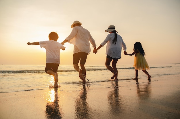 Happy asian family at consisting father motherson and daughter having fun playing beach in summer vacation on the beachHappy family and vacations concept