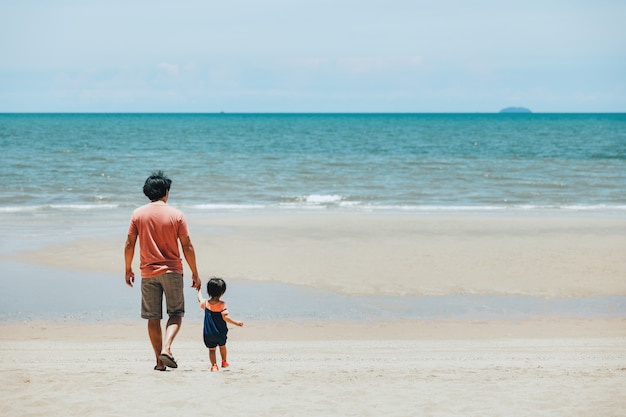 Felice famiglia asiatica padre e figlio si rilassano e visitano insieme la spiaggia al giorno in thailandia, concetto di vacanza estiva