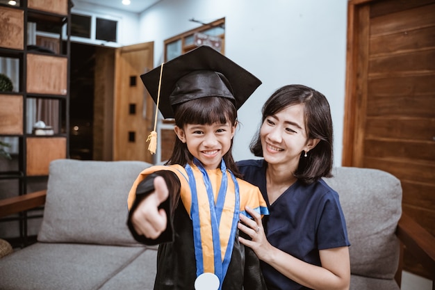 Happy asian family graduate at home elementary school student at home celebrating