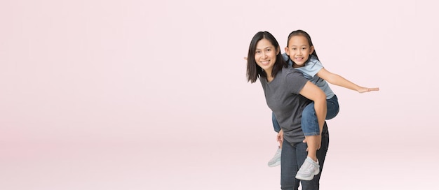 엄마와 딸이 포옹하는 행복한 아시아 가족은 디자인 작업을 위한 클리핑 패스를 사용하여 분홍색 배경에 격리된 팔을 벌리고 빈 여유 공간을 껴안습니다.