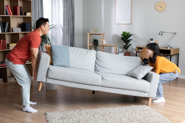 Happy asian family moving furniture at their new house