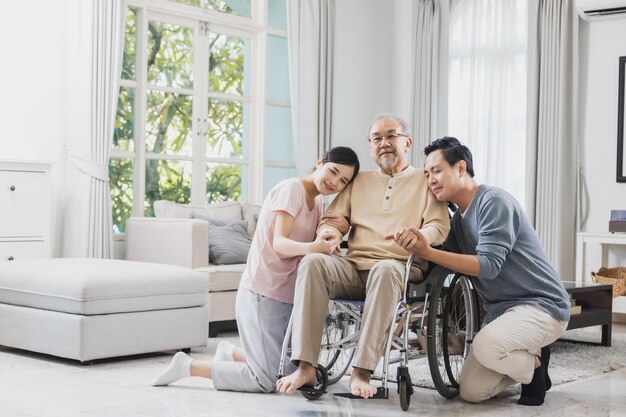 happy Asian family senior man on wheelchair with daughter and son at home