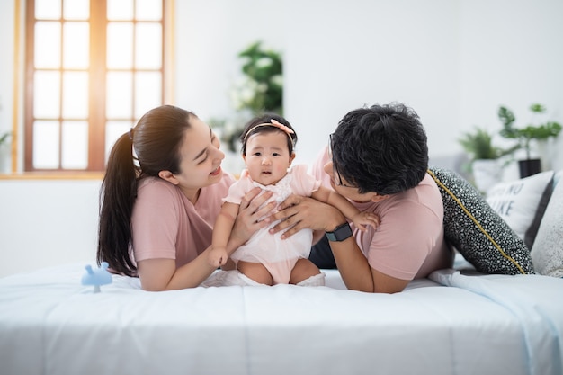 自宅の子供の寝室に座っている幸せなアジアの家族