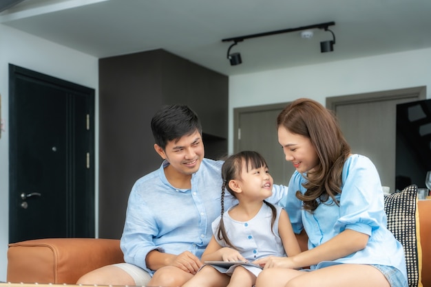 Happy Asian family sitting on sofa