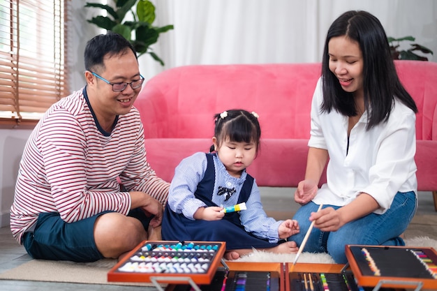 Felice famiglia asiatica sorridente insieme a casa