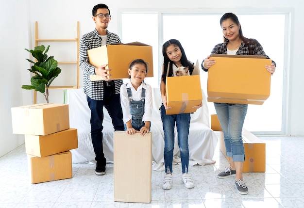 Happy Asian family with children and a cat moving into new house