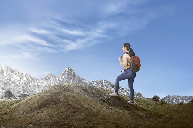 Happy asian female traveler with backpack walking