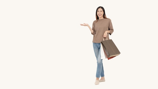 A happy Asian female with her shopping bags standing against an isolated white background