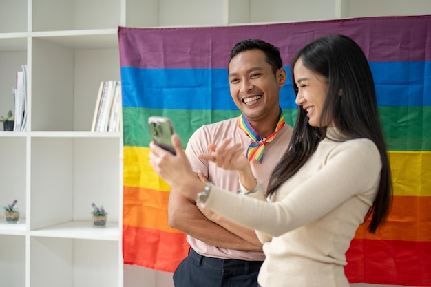 幸せなアジア人のゲイの男性は、ビデオブログの録画やガールフレンドとの自撮りを楽しんでいます