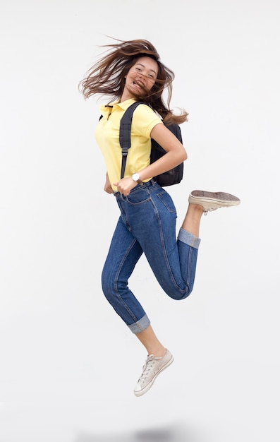 Happy asian girl jumping action with school bag on white isolated background