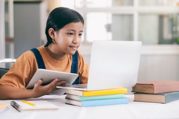 Happy asian girl learning online at home