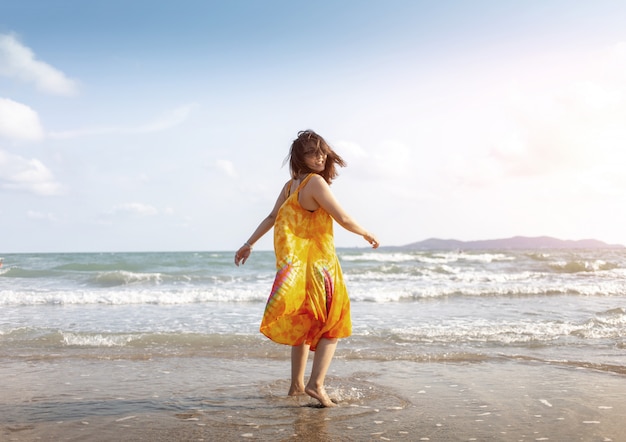 Happy asian girl on ocean beach in vocation