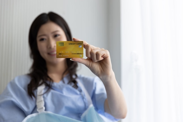 사진 신용 카드로 병원 침대에 행복 아시아 여자