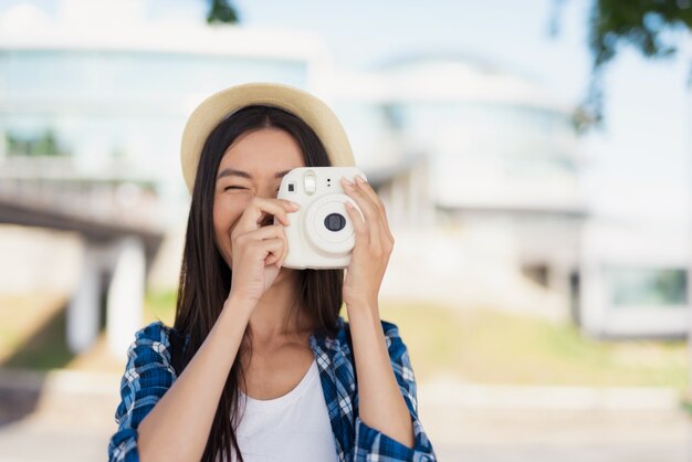 La ragazza asiatica felice prende i ricordi dell'estate della foto.