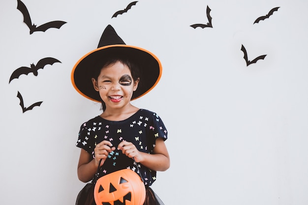 幸せなアジアの小さな子供の衣装や化粧のハロウィーンのお祝いに楽しんで