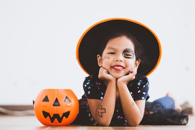 Happy asian little child girl in costumes and makeup having fun on Halloween celebration