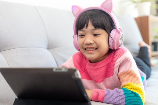 A Happy Asian little girl listening to music in the living-room