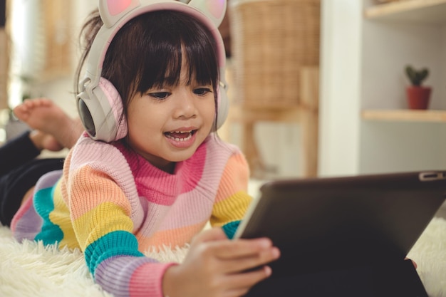 A Happy Asian little girl listening to music in the living-room