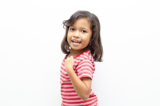 happy asian little girl posing yes gesture with raising her fist shows growing up and strong.