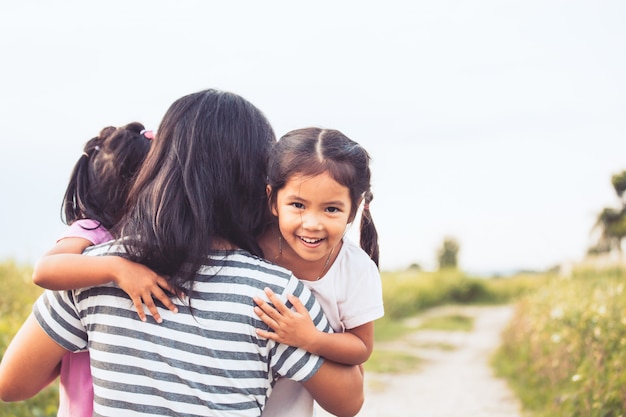 Happy asian little girls hugging mother and having fun to play with mother