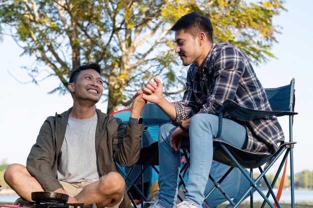 Photo happy asian male gay couple on camping together in a forest romantic vocation trip lgbt concept