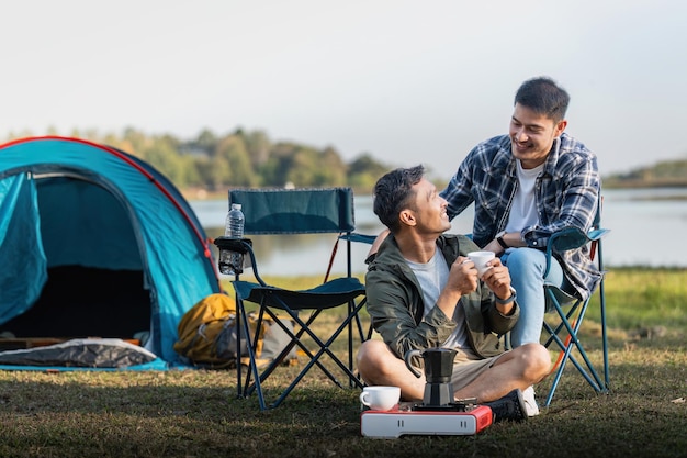 Happy Asian male gay couple on camping together in a forest romantic vocation trip lgbt concept