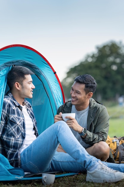 Happy Asian male gay couple on camping together in a forest romantic vocation trip lgbt concept