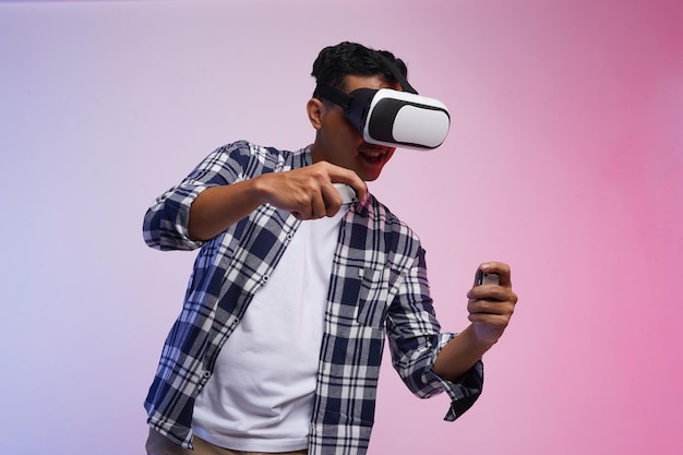 Happy asian man experiencing VR entertainment technology, touching the air learns digital game