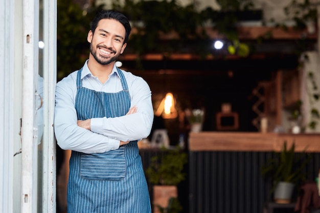 Happy asian man portrait and arms crossed in small business at restaurant for welcome service or job at door Male entrepreneur smile in confidence at entrance ready to serve in coffee shop or cafe