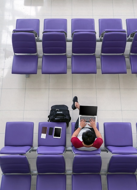 Foto viaggiatore asiatico felice dell'uomo che lavora con il computer portatile di tecnologia