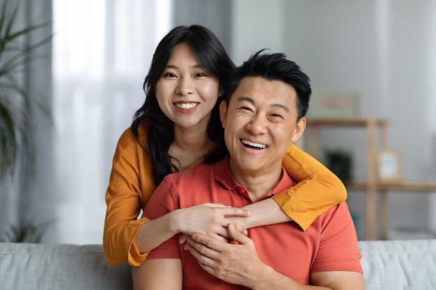 Happy asian man and woman posing together at home